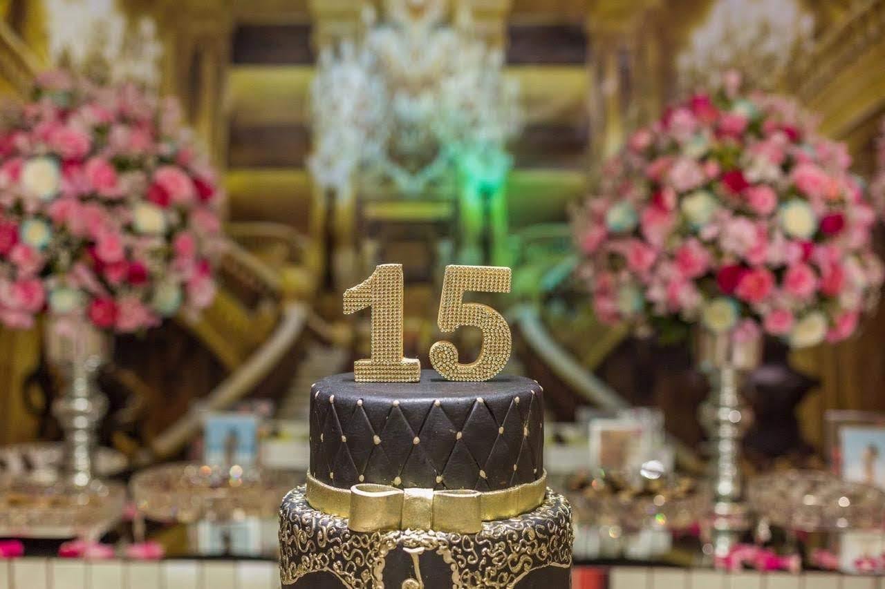 Decoração dourada de festa de 15 anos no Spazio Cezane, com bolo e flores